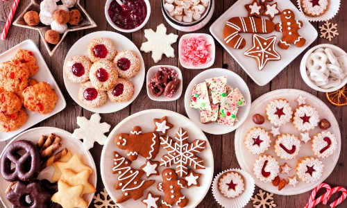 A table of Christmas baked goods like mince pies and gingerbread