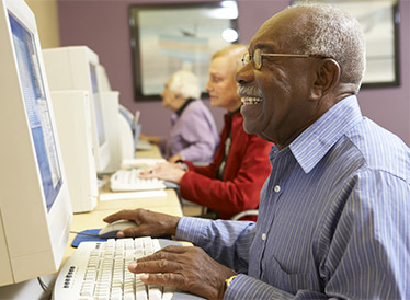 A black man sat at a computer